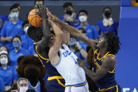 California forward Kuany Kuany, left, guard Joel Brown, right, and UCLA guard Jules Bernard (1) battle for possession of the ball during the first half of an NCAA college basketball game in Los Angeles, Thursday, Jan. 27, 2022. (AP Photo/Ashley Landis)