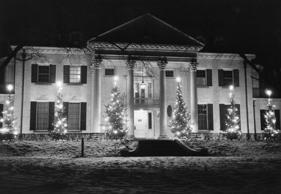 The home of Chicago Tribune publisher Robert R. McCormick in Wheaton, Illinois. There is snow on the ground and lights in the trees.