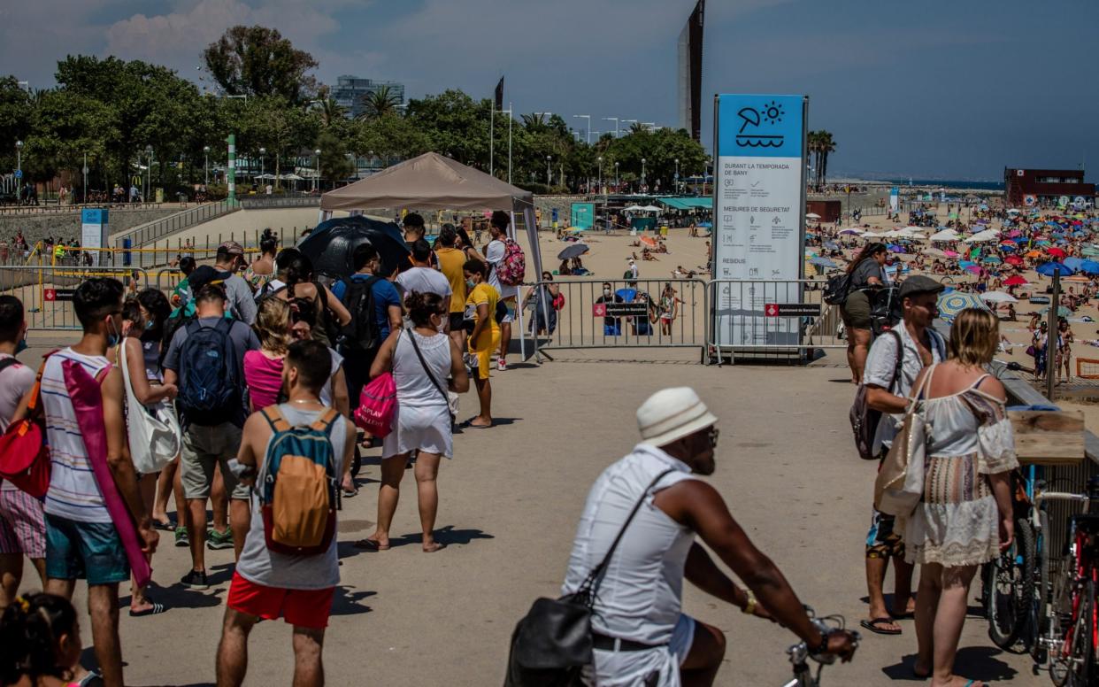 Visitors queue for entry at an access point to Nova Icaria beach in Barcelona - Angel Garcia/Bloomberg