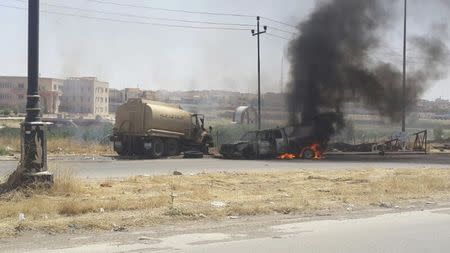 Burning vehicles belonging to Iraqi security forces are seen during clashes between Iraqi security forces and al Qaeda-linked Islamic State in Iraq and the Levant (ISIL) in the northern Iraq city of Mosul, June 10, 2014. REUTERS/Stringer