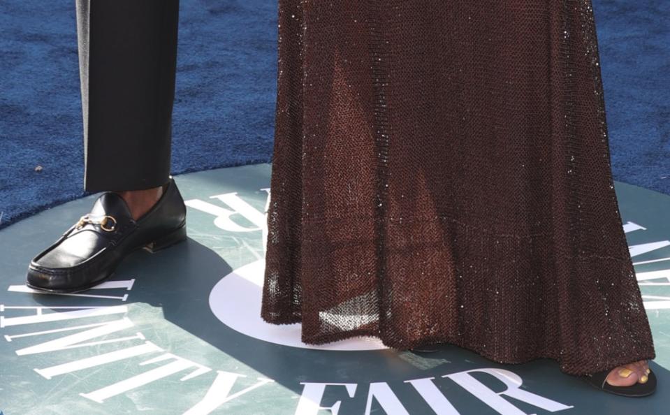 A closer look at Wade and Union’s shoes on the red carpet at the Vanity Fair Oscars party. While he wore black leather horsebit loafers she showed off yellow toenails in black sandals. - Credit: Variety