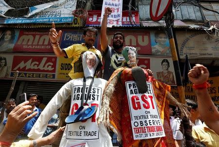 Cloth merchants and workers shout slogans before burning the effigies depicting India's Finance Minister Arun Jaitley and Textiles Minister Smriti Irani during a protest against implementation of Goods and Services Tax (GST) on textiles, in Kolkata, June 29, 2017. REUTERS/Rupak De Chowdhuri
