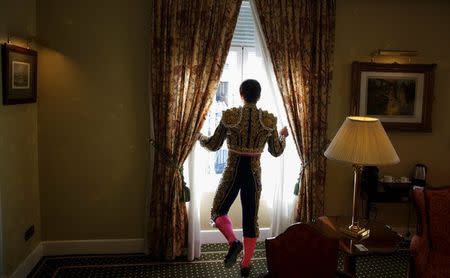 Alberto Lamelas looks out from a window as he wears his bullfighter outfit in a hotel room before taking part in a bullfighting during San Isidro festival at Las Ventas bullring in Madrid, Spain, June 5, 2017. REUTERS/Sergio Perez