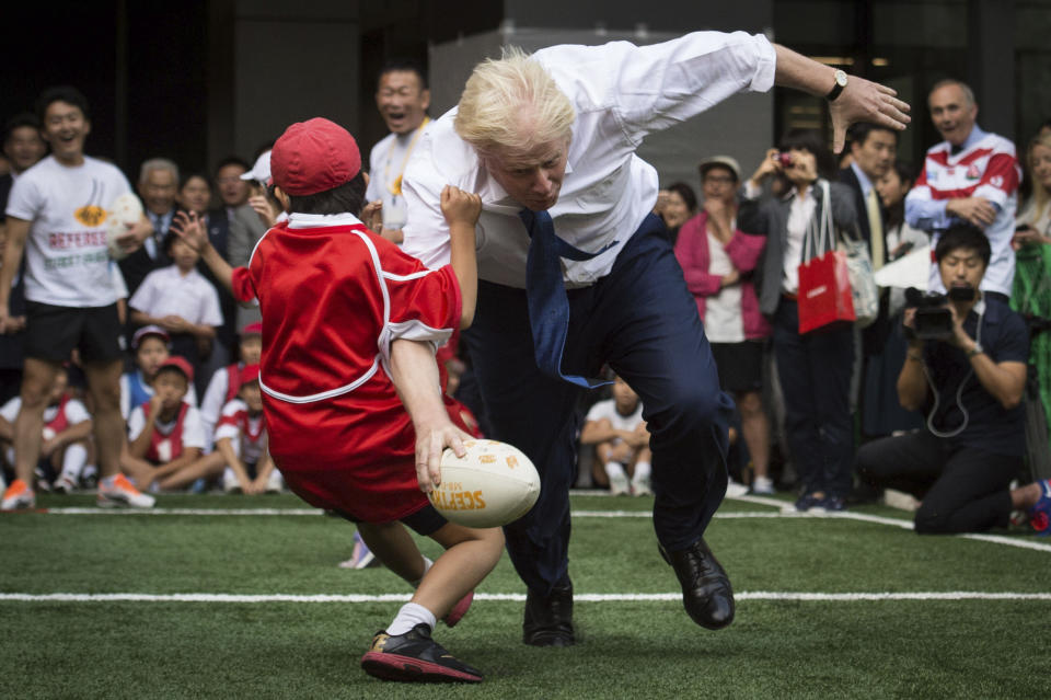 FILE - In this Oct. 15, 2015 file photo, Boris Johnson takes part in a Street Rugby tournament in a Tokyo street. Britain's new top diplomat is shaggy-haired, Latin-spouting Boris Johnson, who in recent months has made insulting and vulgar comments about the presidents of the United States and Turkey. (Stefan Rousseau/PA via AP)