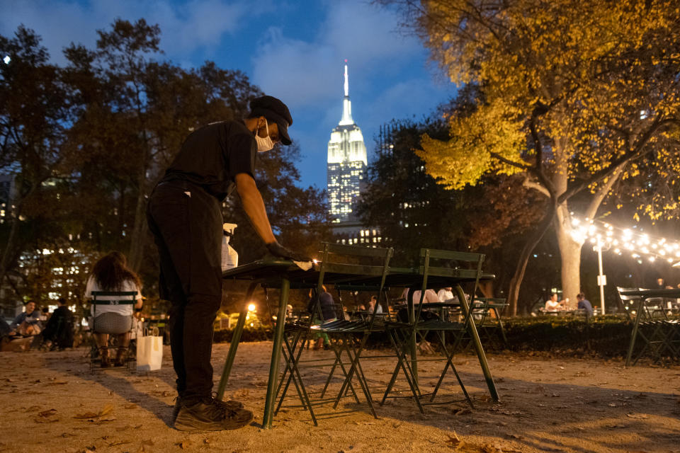 NEW YORK, NEW YORK - NOVEMBER 10: A shake Shack employee cleans and sanitizes an outdoor table at Madison Square Park on November 10, 2020 in New York City. The pandemic continues to burden restaurants and bars as businesses struggle to thrive with evolving government restrictions and social distancing plans which impact keeping businesses open yet challenge profitability. (Photo by Alexi Rosenfeld/Getty Images)