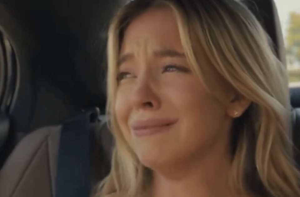 Woman in a car appearing distressed or on the verge of tears