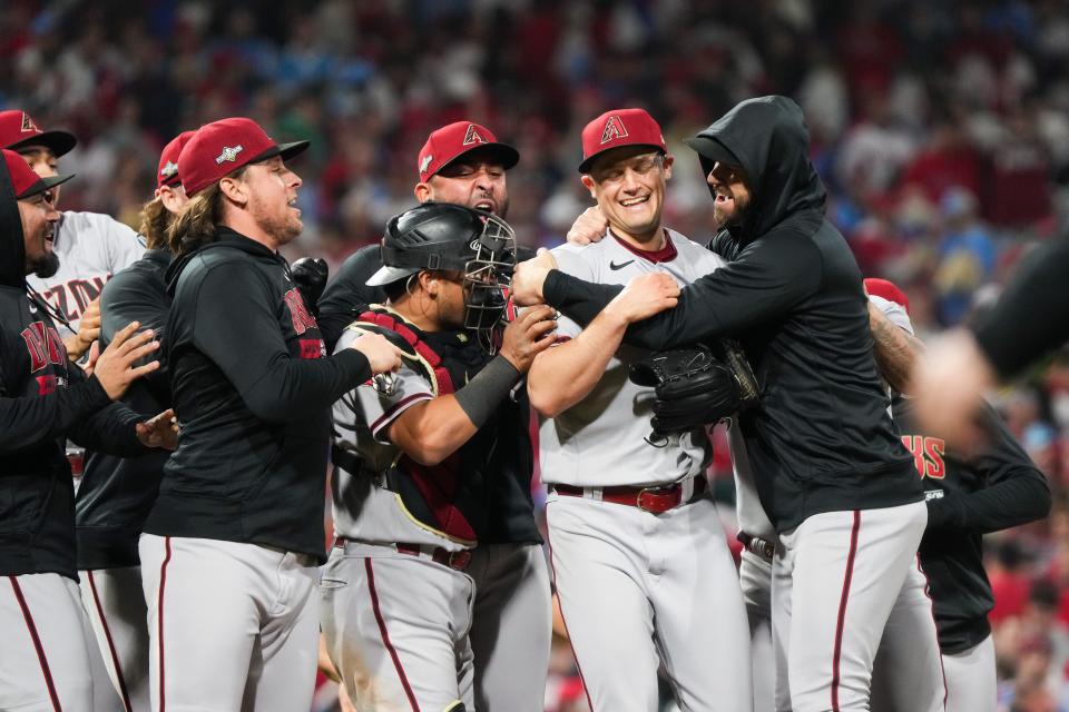 Arizona Diamondbacks relief pitcher Paul Sewald (38) is surrounded by teammates after defeating the Philadelphia Phillies in game seven of the NLCS at Citizens Bank Park in Philadelphia on Oct. 24, 2023.