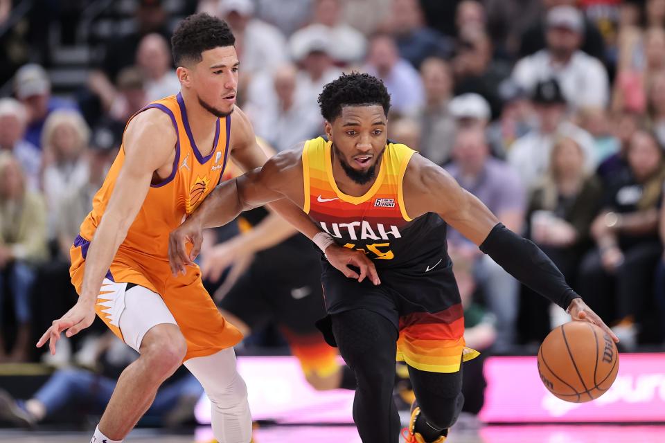 Apr 8, 2022; Salt Lake City, Utah, USA; Utah Jazz guard Donovan Mitchell (45) brings the ball up the court defended by Phoenix Suns guard Devin Booker (1) in the second quarter at Vivint Arena.