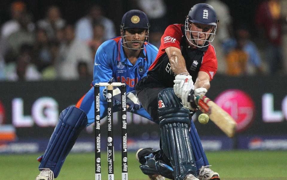 Andrew Strauss of England sweeps with MS Dhoni of India looking on