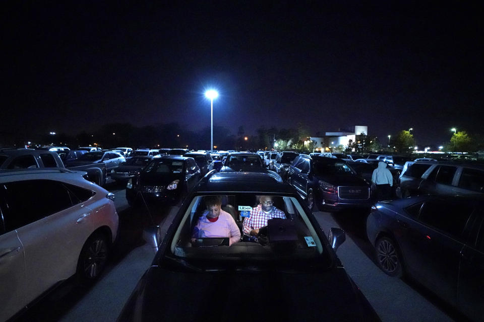 Norman Butler, a first time food bank user, and his girlfriend Cheryl Butler wait overnight in their car, along with others lined up to receive food at a distribution point in Metairie, La., Thursday, Nov. 19, 2020. Before the pandemic, Norman, 53, flourished in the tourism-dominated city, working as an airport shuttle and limousine driver, a valet and hotel doorman. Since March when the normally bustling streets turned silent, the only work he’s had has been as an Uber driver. (AP Photo/Gerald Herbert)