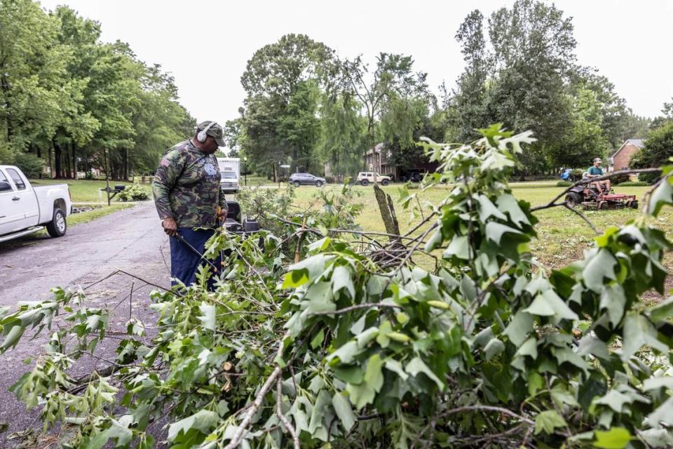 Charles Coleman cleans up tornado damage outside his home in Harrisburg, N.C., on Tuesday, May 24, 2022.