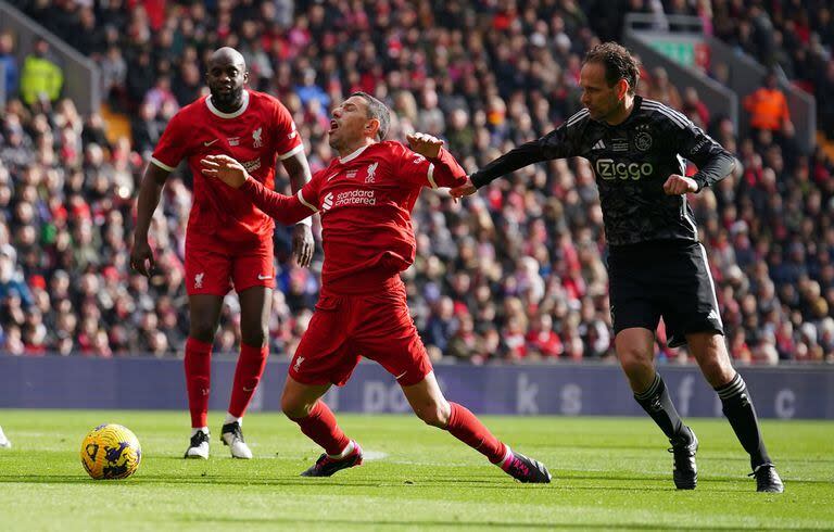 La falta sobre Maxi Rodríguez de Olaf Lindenbergh durante el partido entre las leyendas de Liverpool y Ajax, en un Anfield benéfico.