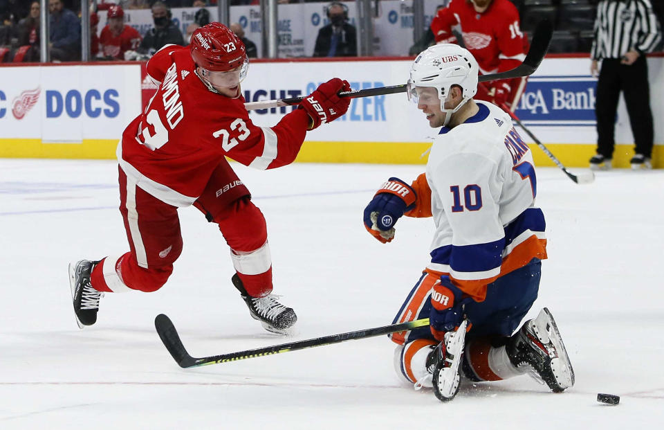 Detroit Red Wings left wing Lucas Raymond (23) takes a shot on goal against New York Islanders center Austin Czarnik (10) during the first period of an NHL hockey game Saturday, Dec. 4, 2021, in Detroit. (AP Photo/Duane Burleson)