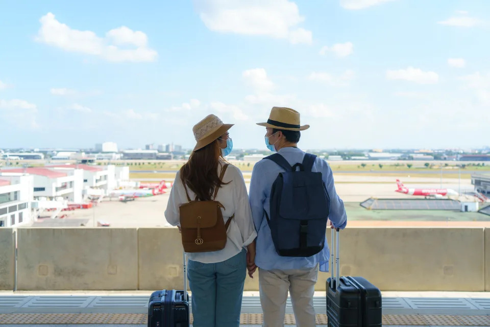 Asian travelers couple waiting train at the train station in Bangkok, Thailand, Travel and transportation concept