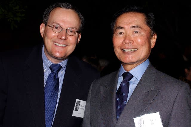 <p>Amanda Edwards/Getty</p> Brad and George Takei in 2003