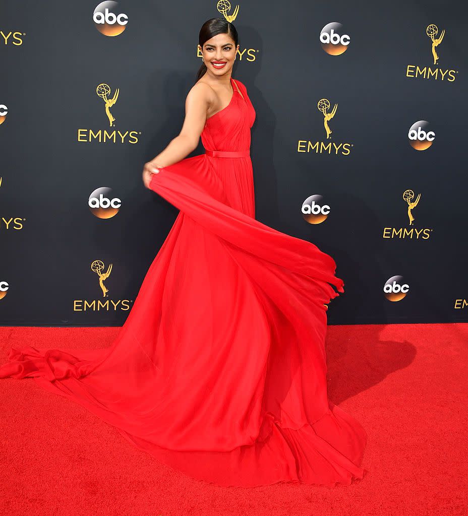 <p>In a vibrant red one-shouldered gown. </p>