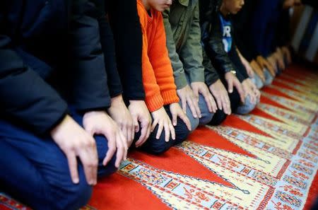 Muslims pray during Friday prayers at the Turkish Kuba Camii mosque located near a hotel housing refugees in Cologne's district of Kalk, Germany, October 14, 2016. REUTERS/Wolfgang Rattay