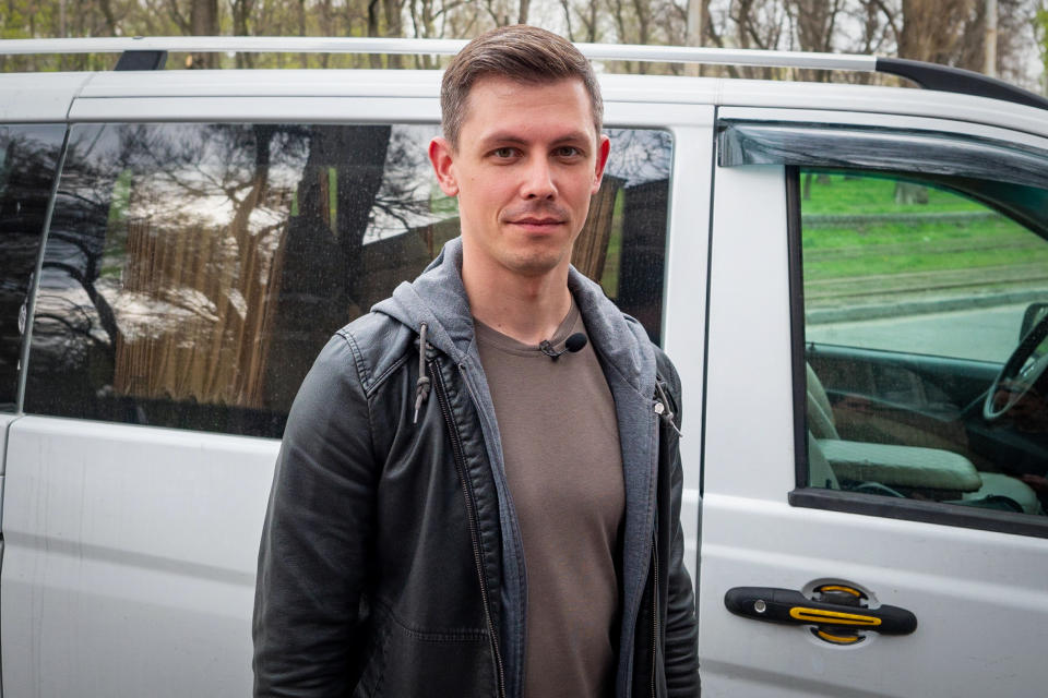 Ballroom dance instructor Nazar Shashkov stands in front of his van, which he used to rescue to his students from his besieged hometown of Mariupol. (Mo Abbas / NBC News)