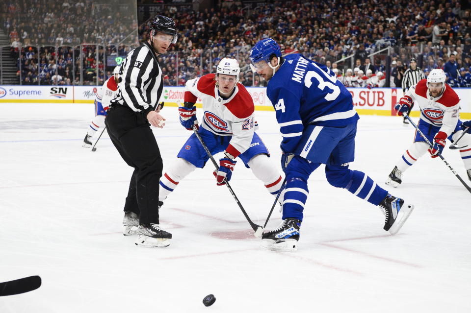 Toronto Maple Leafs forward Auston Matthews (34) and Montreal Canadiens forward Christian Dvorak (28) face off during first-period NHL hockey game action in Toronto, Saturday, Feb. 18, 2023. (Christopher Katsarov/The Canadian Press via AP)