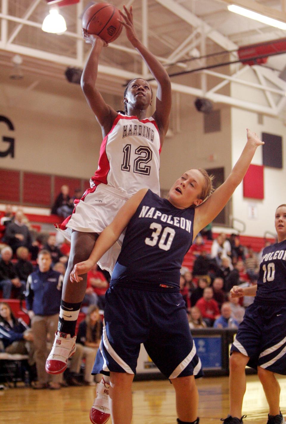 Marion Harding's Shawnta Dyer floats above Megan Zachrich for a basket during a home basketball game against Napoleon in 2010. Dyer is a member of the 30th induction class for the Marion Harding High School Athletic Hall of Fame.