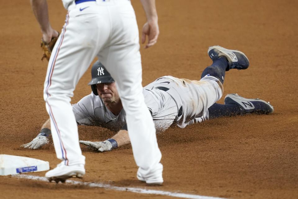 Texas Rangers shortstop Charlie Culberson, front, stands by the bag as New York Yankees' Brett Gardner slides safely into it with a triple in the fourth inning of a baseball game in Arlington, Texas, Monday, May 17, 2021. (AP Photo/Tony Gutierrez)