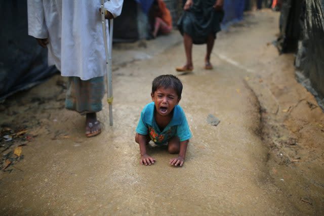 A Rohingya child cries kneeling on the ground at a makeshift camp near Kutupalong refugee camp in Cox's Bazar, Bangladesh