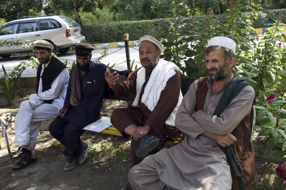 In this Tuesday, Oct. 1, 2019, photo, Aziz Rahman, second, right, a village elder, who had contracted the farmers to harvest the pine nuts, speaks during an interview to the Associated Press in Jalalabad city east of Kabul, Afghanistan, Anger is mounting over the increasing numbers of civilians dying in misdirected US aerial strikes and heavy- handed tactics of CIA-trained Afghan force. Some Afghans calling for Americans to be tried in Afghan courts (AP Photo/Rahmat Gul)