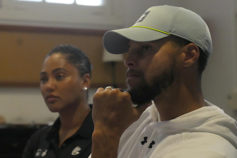 Golden State Warriors basketball player Stephen Curry, right, is interviewed next to his wife, Ayesha, at Stanford Golf Course in Stanford, Calif., Monday, Aug. 28, 2023. The Currys and partners are expanding the reach of their Eat.Learn.Play. Foundation, established in 2019 to support youth in Oakland, the Bay Area and beyond, while striving to improve lives of families nationwide. They are generating $50 million in additional funding to assist the Oakland Unified School District. (AP Photo/Jeff Chiu)