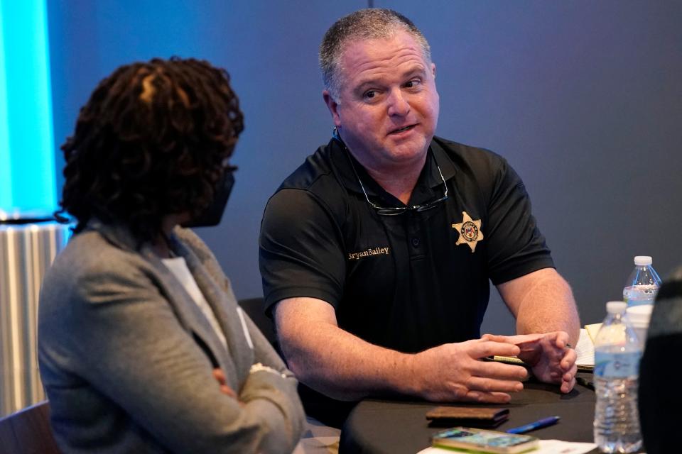 Rankin County Sheriff Bryan Bailey, right, speaks to an attendee at an employer engagement forum in Jackson, Miss., Nov. 4, 2021. Bailey, the Mississippi sheriff who leads the department where former deputies pleaded guilty to a long list of state and federal charges for the racist torture of two Black men has asked a federal court to dismiss a civil lawsuit against him, Friday, Oct. 6, 2023. (AP Photo/Rogelio V. Solis, File)