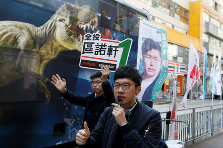 Pro-democracy activist Joshua Wong (L) and disqualified lawmaker Nathan Law urge people to vote for pro-democracy candidate Au Nok-hin during a Legislative Council by-election in Hong Kong, China March 11, 2018. REUTERS/Bobby Yip