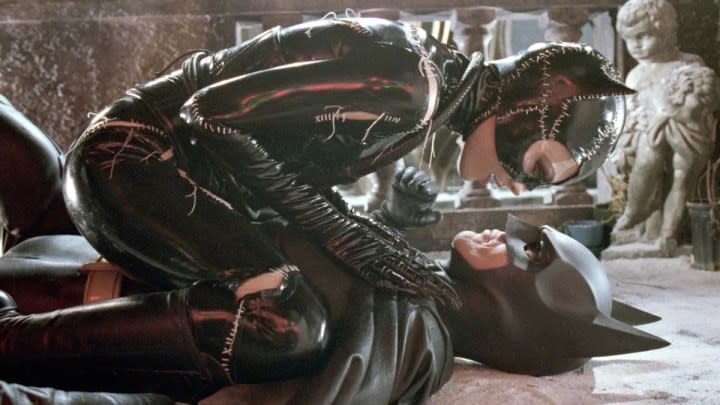 Michelle Pfeiffer's Catwoman sits on top of Michael Keaton's Batman in Batman Returns.