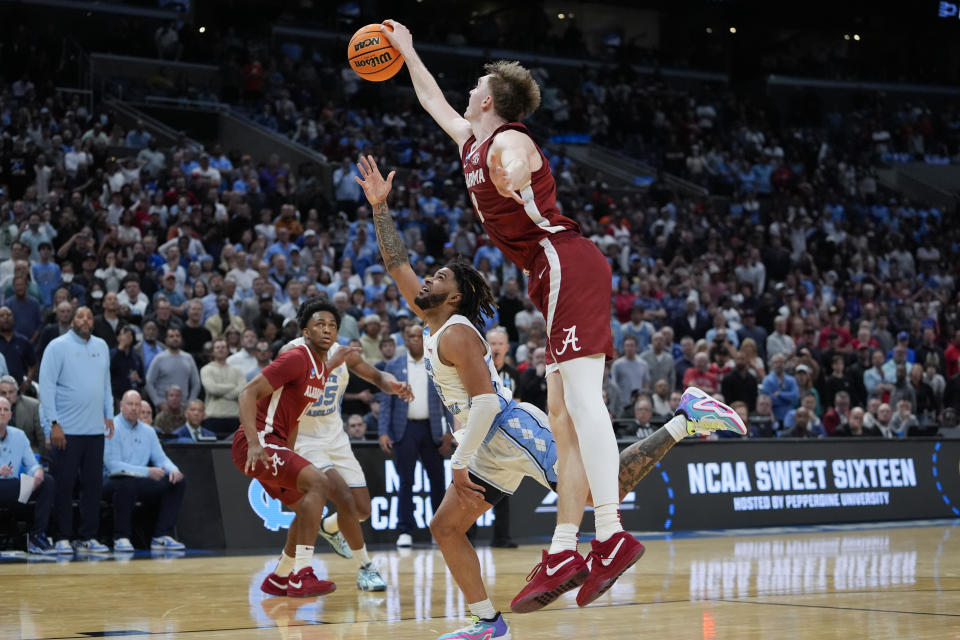 Alabama forward Grant Nelson, right, blocks a shot from North Carolina guard RJ Davis (4) during the second half of a Sweet 16 college basketball game in the NCAA tournament Thursday, March 28, 2024, in Los Angeles. (AP Photo/Ryan Sun)