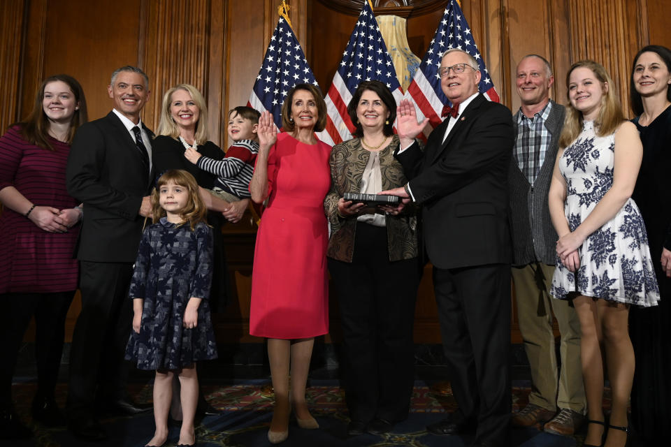 FILE - In this Jan. 3, 2019 file photo, House Speaker Nancy Pelosi of Calif., poses during a ceremonial swearing-in with Rep. Ron Wright, R-Texas, fourth from right, on Capitol Hill in Washington during the opening session of the 116th Congress. Wright, the Texas Republican who had battled health challenges over the past year including lung cancer treatment died Sunday, Feb. 7, 2021, more than two weeks after contracting COVID-19, his office said Monday, Feb. 8. He was 67. (AP Photo/Susan Walsh, File)