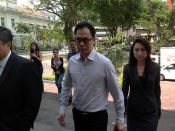 Former CNB director Ng Boon Gay enters the Subordinate Courts on Tuesday afternoon, accompanied by his wife Yap Yen Yen (right). (Yahoo! photo/Jeanette Tan)