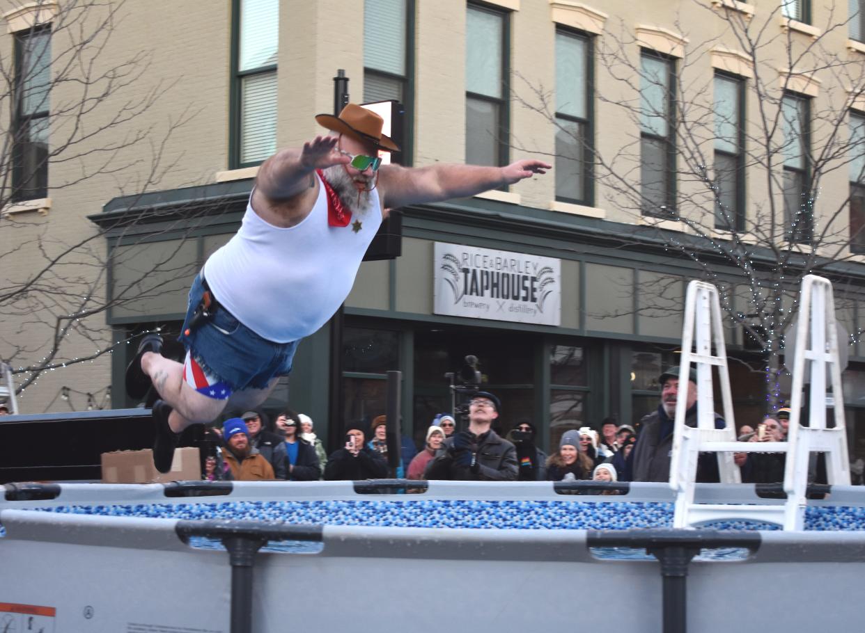 Jack Still, owner of Greenjack Inc., a recycling center in Morenci, catapults toward a pool of icy, cold water Friday, Feb. 3, 2023, during the Maple Frost Plunge in downtown Adrian. The event, which was as a fundraiser for various organizations in Lenawee County, was the headlining feature of downtown Adrian's First Fridays for February.