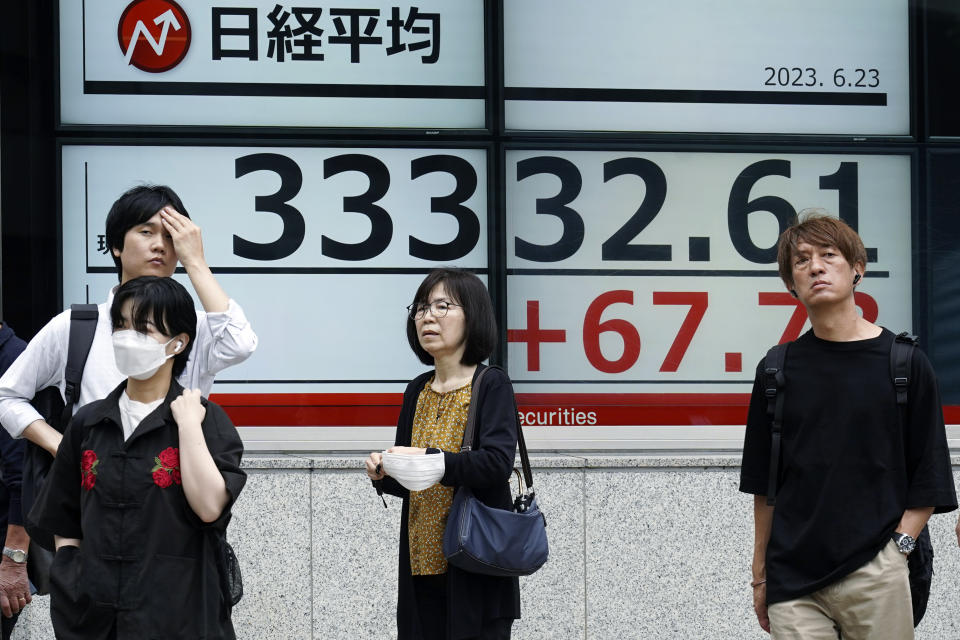 People stand in front of an electronic stock board showing Japan's Nikkei 225 index at a securities firm Friday, June 23, 2023, in Tokyo. Asian shares sank sharply Friday after several central banks around the world cranked interest rates higher in their fight against inflation.(AP Photo/Eugene Hoshiko)