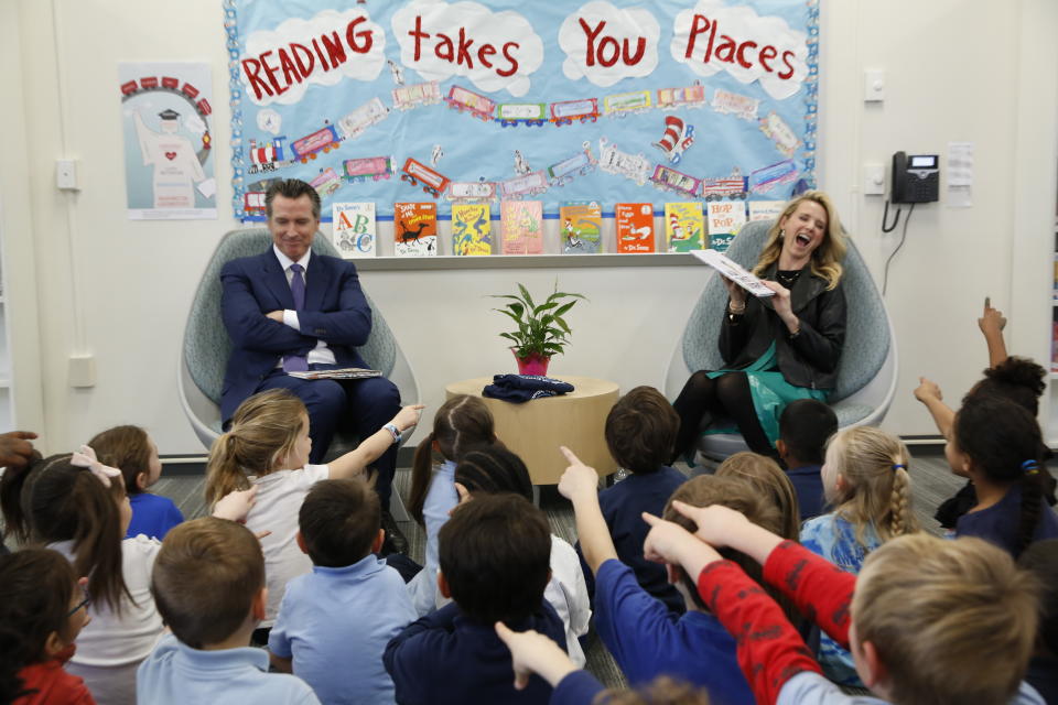 FILE-- IN this March 1, 2019 file photo first partner, Jennifer Siebel Newsom gets a laugh at the expense of her husband, Gov. Gavin Newsom as she reads the book "Ada Twist, Scientist" by Andrea Beaty and David Roberts, to kindergarteners at the Washington Elementary School in Sacramento, Calif. Siebel Newsom visited the school, with her husband to celebrate Read Across America Day. She often attends events with her husband but also works on issues of her own including equal rights for women. (AP Photo/Rich Pedroncelli, File)