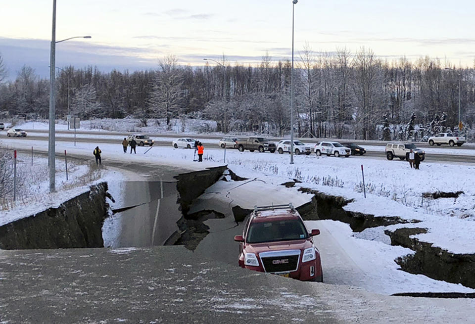 FILE - In this Friday, Nov. 30, 2018 file photo, a vehicle is trapped on a section of road that collapsed during an earthquake in Anchorage, Alaska. The collapsed roadway that became an iconic image of the destructive force of a magnitude 7.0 earthquake and its aftershocks was repaired just days after the quake. The off-ramp connecting Minnesota Drive and a road to Ted Stevens Anchorage International Airport reopened Tuesday, Dec. 4, 2018, with shoulder work finished Wednesday. (AP Photo/Dan Joling, File )