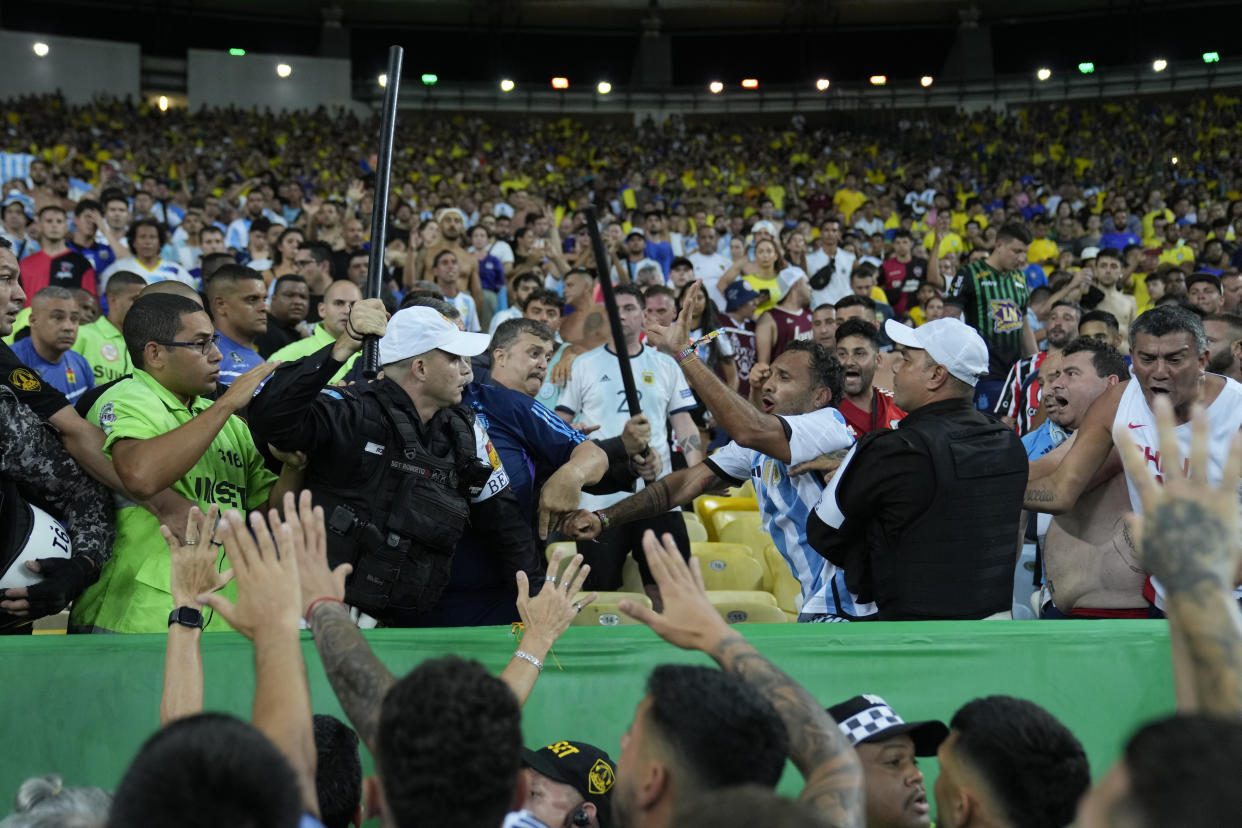 Police try to stop a fight between Brazilian and Argentinian fans that broke out prior to a qualifying soccer match for the FIFA World Cup 2026 between Brazil and Argentina at Maracana stadium in Rio de Janeiro, Brazil, Tuesday, Nov. 21, 2023. (AP Photo/Silvia Izquierdo)