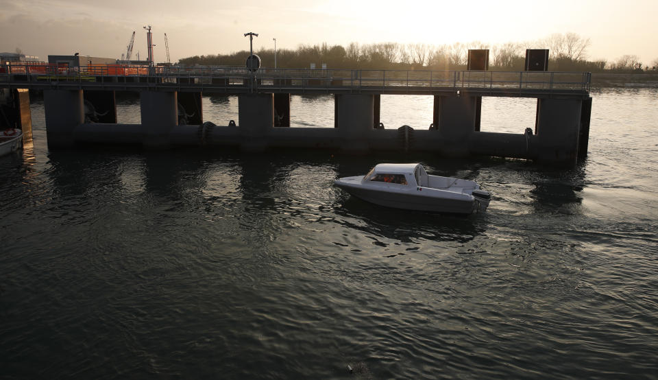 A boat sails past a construction of the Moses project in Venice, Italy, Friday, Nov. 29, 2019. In the wake of last month’s flooding of Venice, the worst in 53 years, the consortium that oversees construction of the Moses, a system of moveable under water barriers, is eager to demonstrate that the project -- after years of bad news -- is on track and will be fully operational by the end of 2021. (AP Photo/Antonio Calanni)