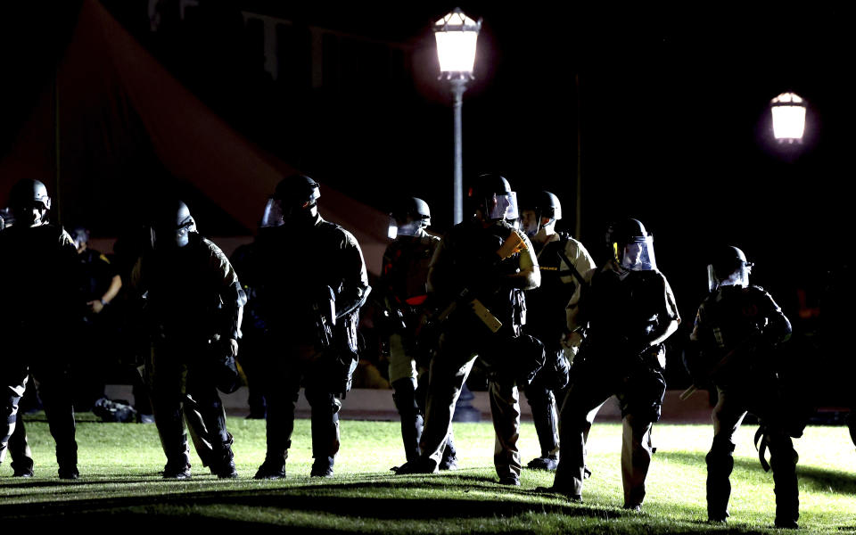 Officers from several area law enforcement agencies form a line and advance on an encampment of pro-Palestinian demonstrators on the University of Arizona campus, Friday, May 10, 2024, Tucson, Az. (Kelly Presnell/Arizona Daily Star via AP)