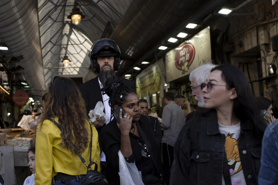 People shop at the Mahane Yehuda market in Jerusalem ahead of Shabbat and the Jewish holiday of Hanukkah, Friday, Nov. 26, 2021. Israel's prime minister says it is "on the threshold of an emergency situation" after authorities detected the country's first case of a new coronavirus variant in a traveler who returned from Malawi. (AP Photo/Maya Alleruzzo)