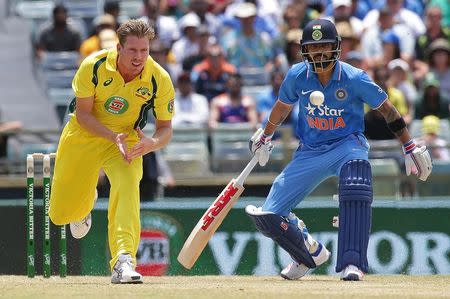 Australia's James Faulkner (L) fields the ball as India's Virat Kohli looks on during the One Day International cricket match in Perth January 12, 2016. REUTERS/Bill Hatto