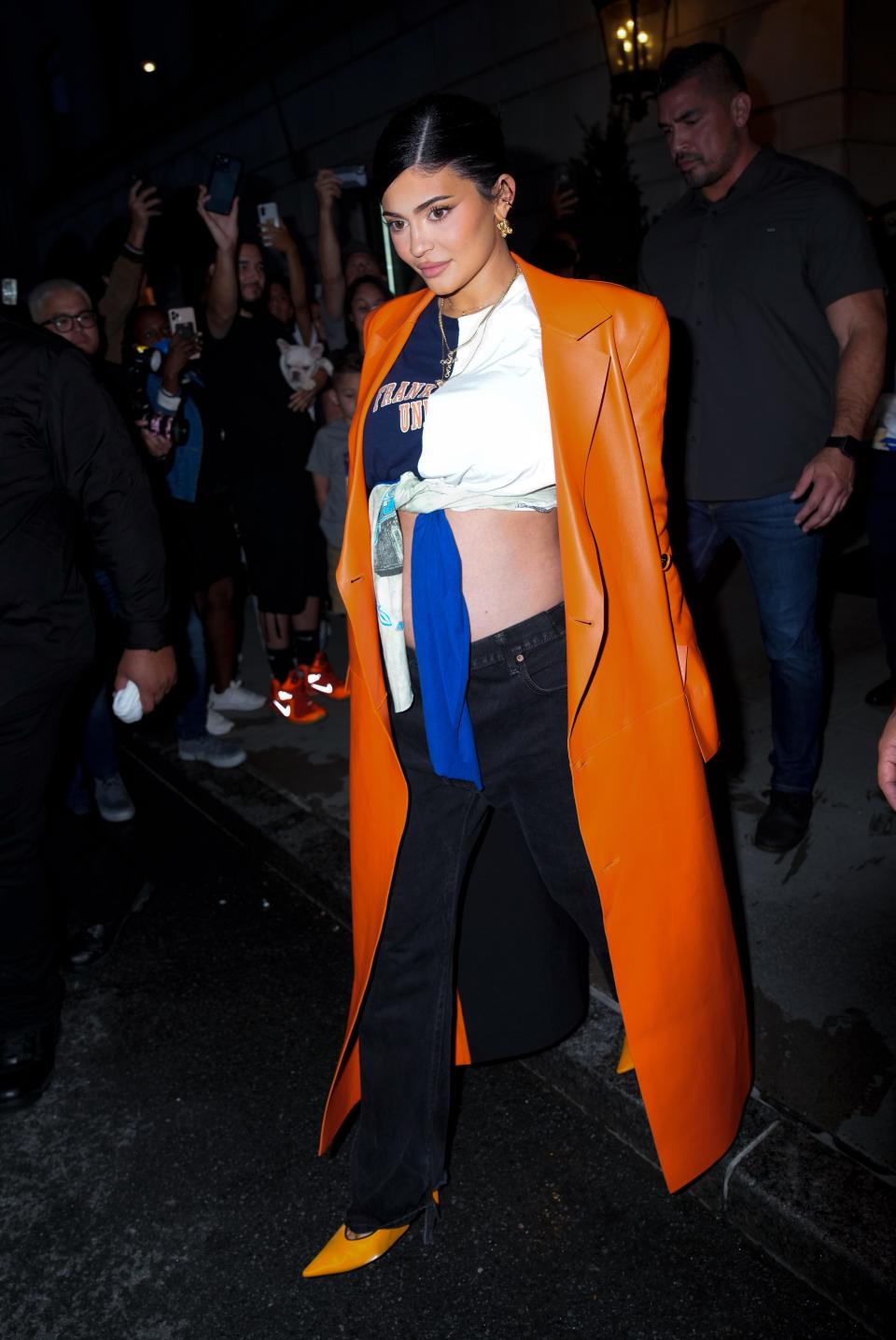 Kylie Jenner wearing an orange Off-White trench coat.