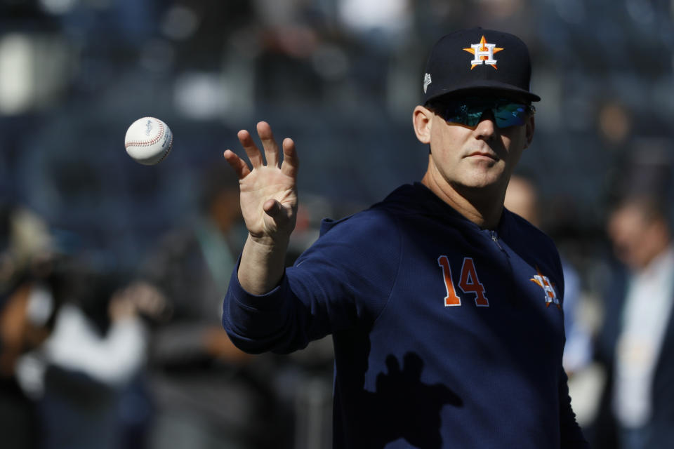 FILE - In this Oct. 15, 2019, file photo, Houston Astros manager AJ Hinch (14) reaches for a ball before Game 3 of baseball's American League Championship Series against the New York Yankees in New York. The Detroit Tigers have hired AJ Hinch to be their new manager, giving him a chance to return to a major league dugout after he was fired by Houston in the wake of the Astros’ sign-stealing scandal. (AP Photo/Matt Slocum, File)