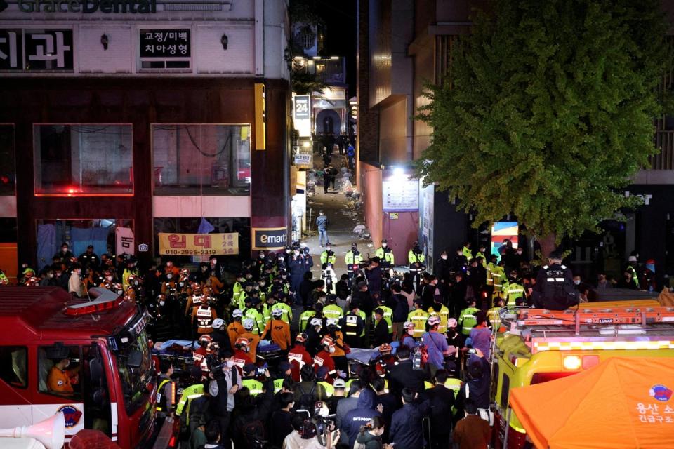 Rescue teams and firefighters work at the scene where people were killed and injured in a crush during Halloween festivities (REUTERS)