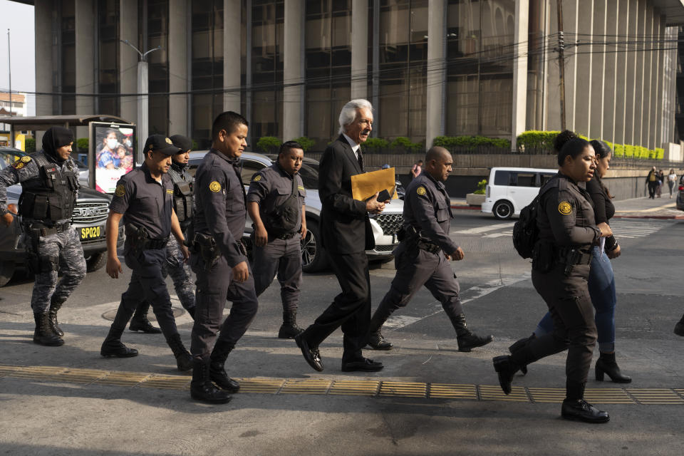 La policía guatemalteca escolta al periodista José Rubén Zamora, fundador del diario El Periódico, que va esposado, hasta un tribunal en la Ciudad de Guatemala, el 15 de mayo de 2024. Una corte ordenó su liberación, luego de pasar dos años retenido acusado de lavado de dinero, hasta que se celebre un nuevo juicio. La fundación del Nobel Gabriel García Márquez había concedido su premio a la excelencia periodística a Zamora en la víspera. (AP Foto/Moisés Castillo)