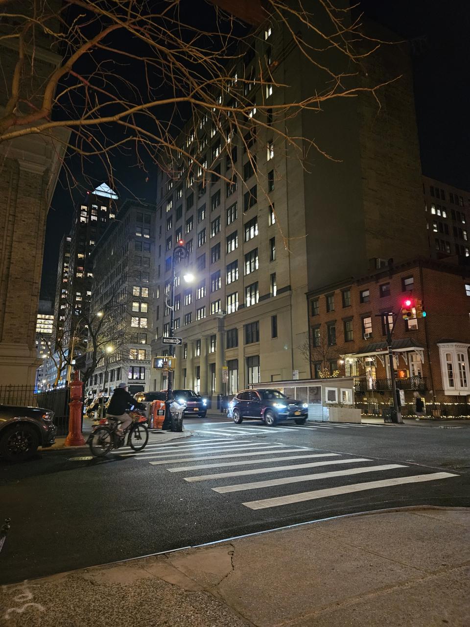 <p>Galaxy S23 Plus camera sample: Manhattan buildings at night in front of a pedestrian crossing.</p>
