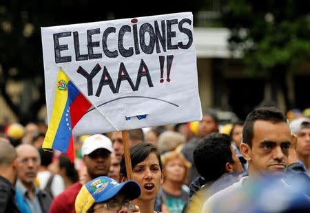 Una manifestante sostiene un cartel pidiendo elecciones de inmediato en Venezuela, en medio de una protesta en Caracas contra el Gobierno del presidente Nicolás Maduro. Foto de archivo. REUTERS/Christian Veron Partidarios de la oposición intentarán desbordar las calles de Venezuela el miércoles en una nueva protesta en contra del presidente Nicolás Maduro, a quien acusan de haber desvirtuado su Gobierno convirtiéndolo en una dictadura.