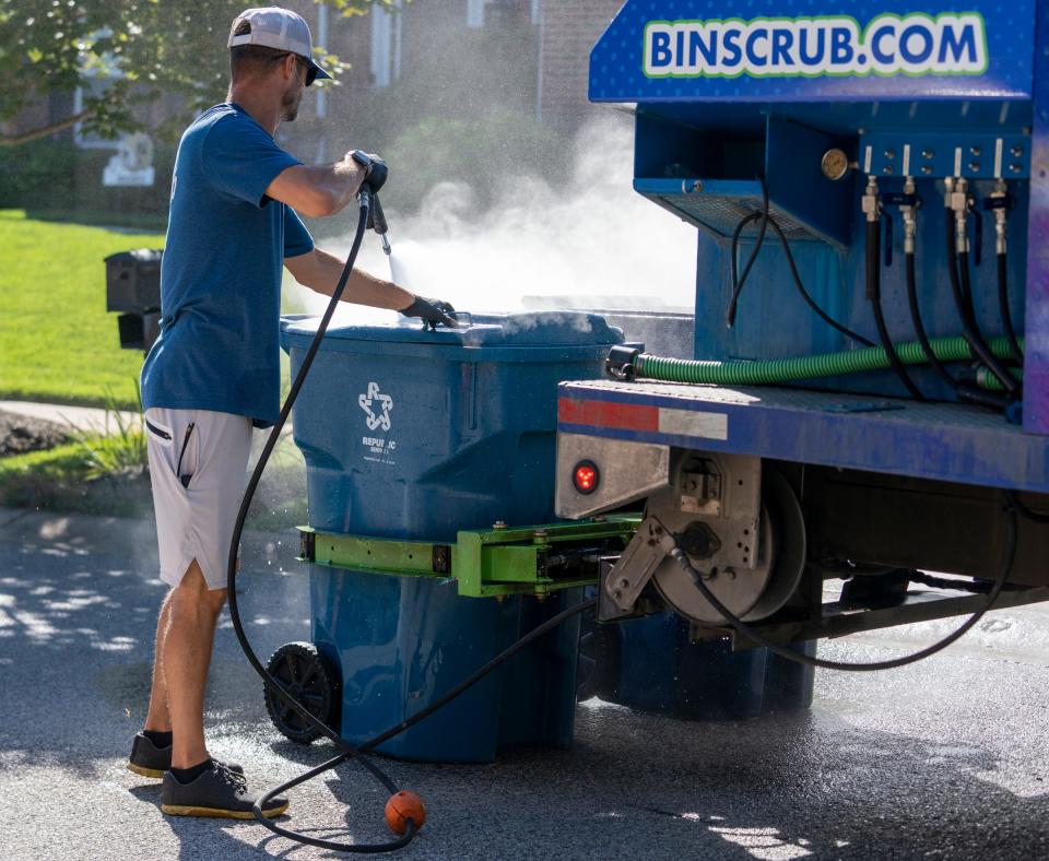 Tyler Taulbee makes a run with one of three trucks used by Bin Scrub, Thursday, Sept. 1, 2022. The service, owned by former Colts player Ryan Diem, has been in operation for the past 2 1/2 years, offers a service that cleans people’s trash and recycling bins. 